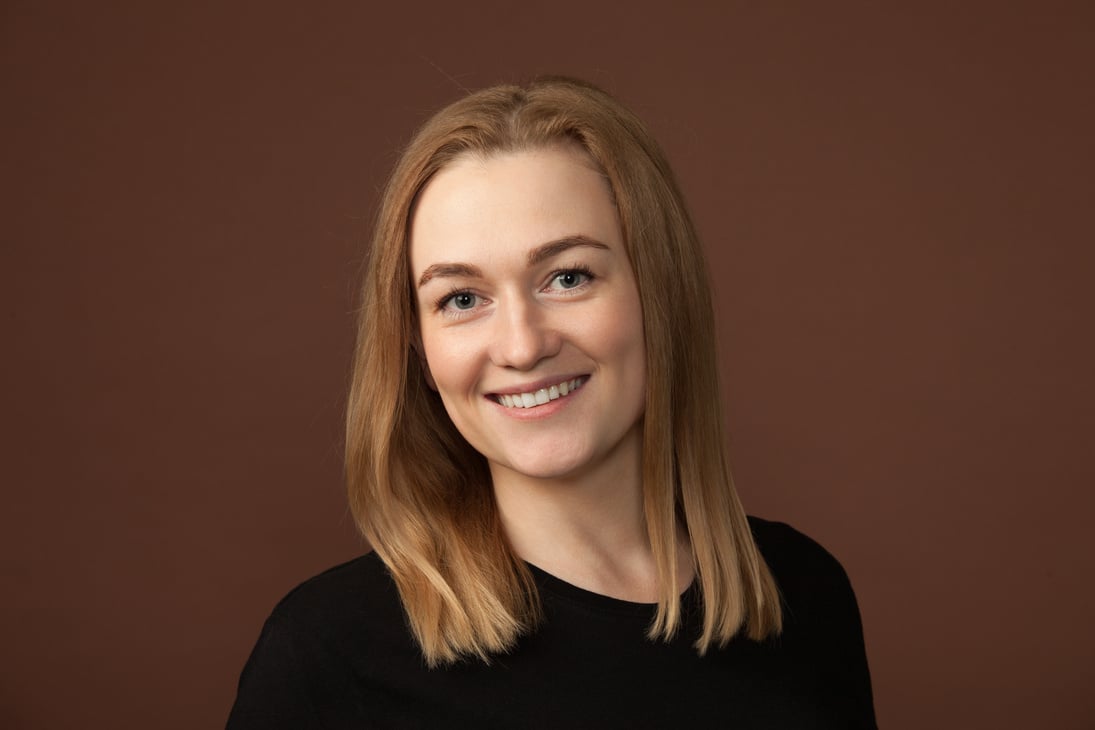 studio portrait of a 30 year old blonde woman on brown background
