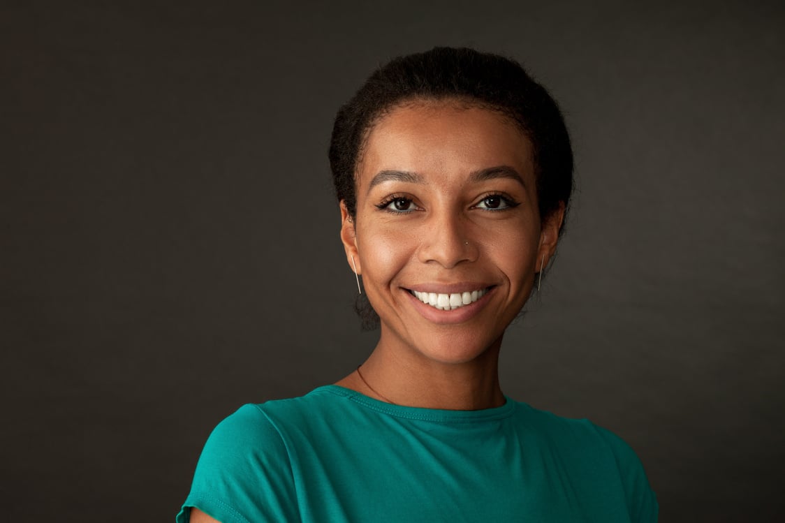 studio portrait of a 30 year old woman on a black background